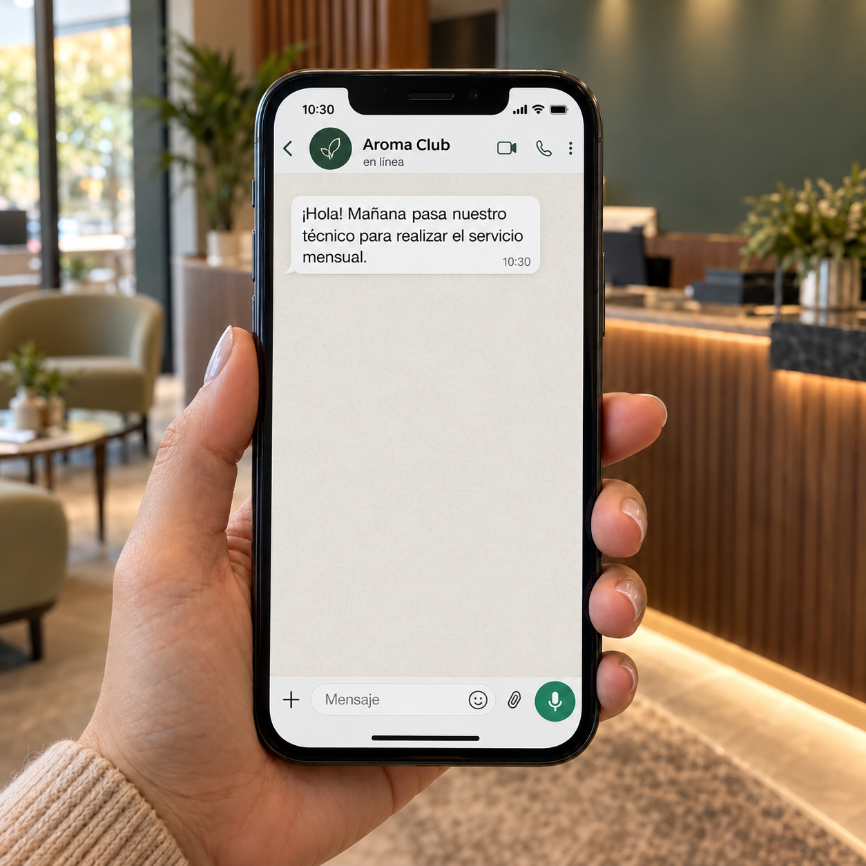 Celular del cliente con un mensaje de Aroma Club avisando la visita del técnico para el servicio mensual.